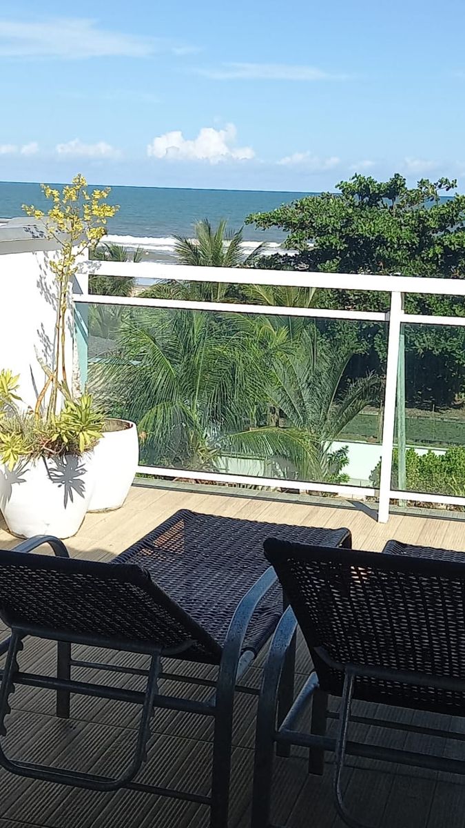 Terraço com espreguiçadeiras e vista para o mar